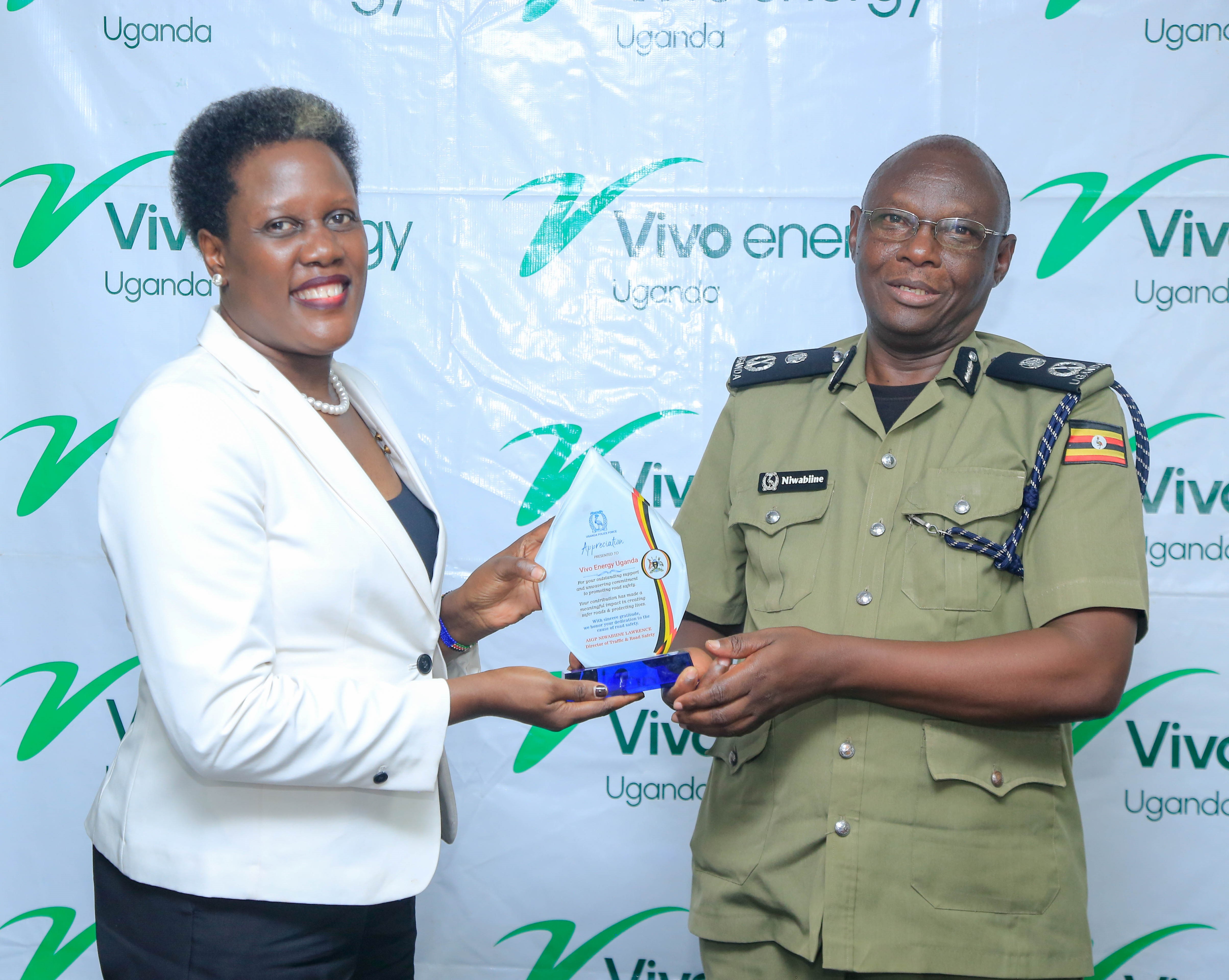 Vivo Energy Uganda MD Joanita Mukasa receives a plaque from aigp lawrence nuwabiine